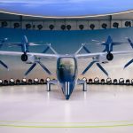 Protótipo de aeronave elétrica com hélices exibido em ambiente interno.