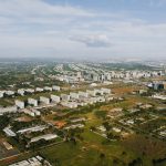 Vista aérea de Brasília, com áreas verdes, edifícios e o traçado urbano da capital federal
