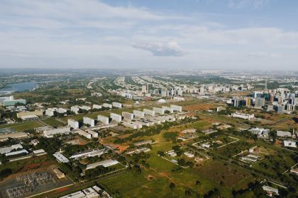 Vista aérea de Brasília, com áreas verdes, edifícios e o traçado urbano da capital federal