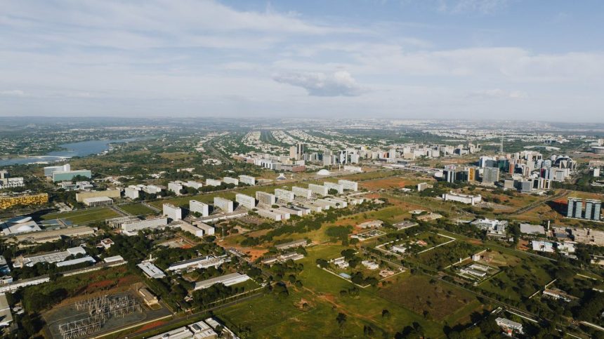 Vista aérea de Brasília, com áreas verdes, edifícios e o traçado urbano da capital federal