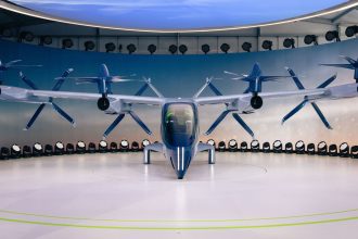 Protótipo de aeronave elétrica com hélices exposto em ambiente interno.